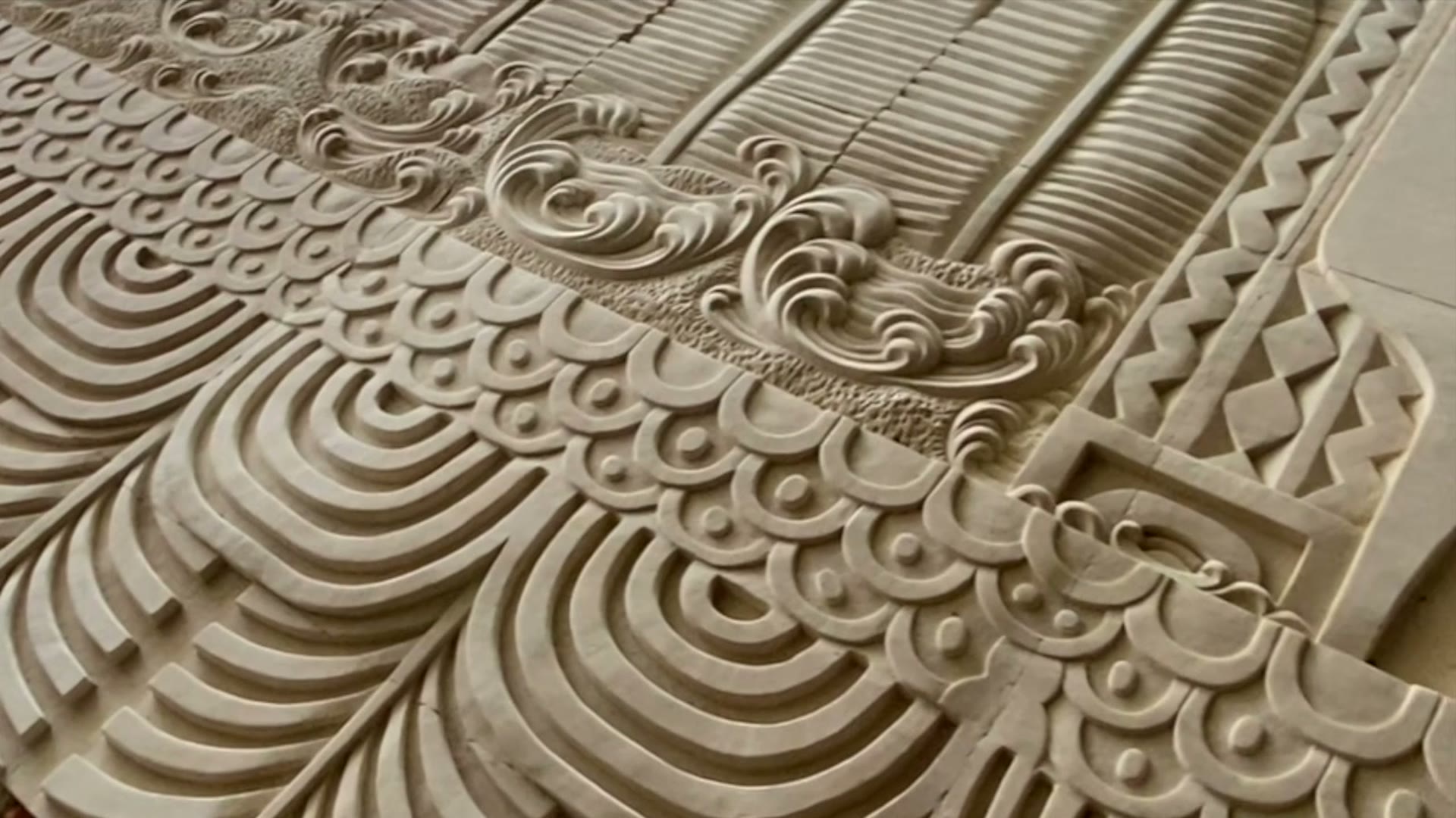 A carved relief panel of waves and arches