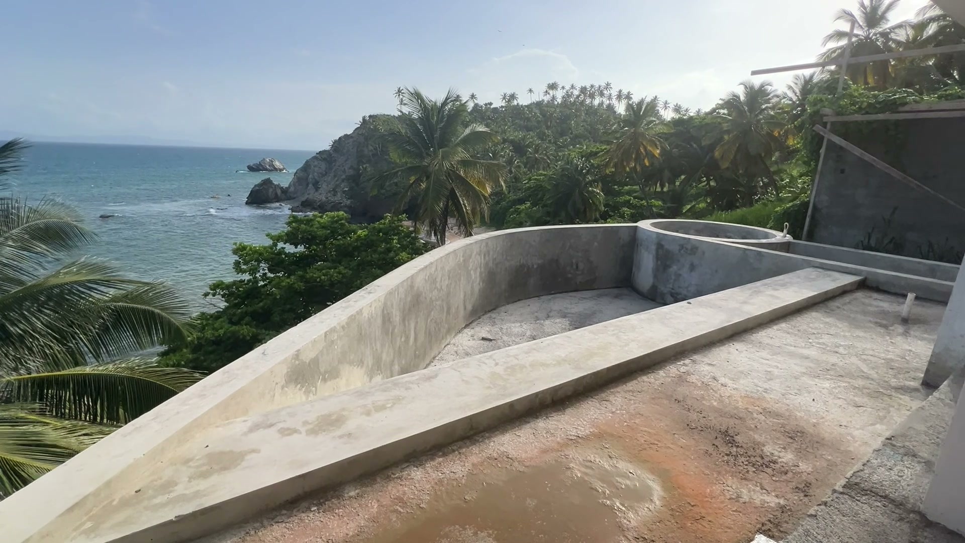 The curved edge of a pool shell above the coast