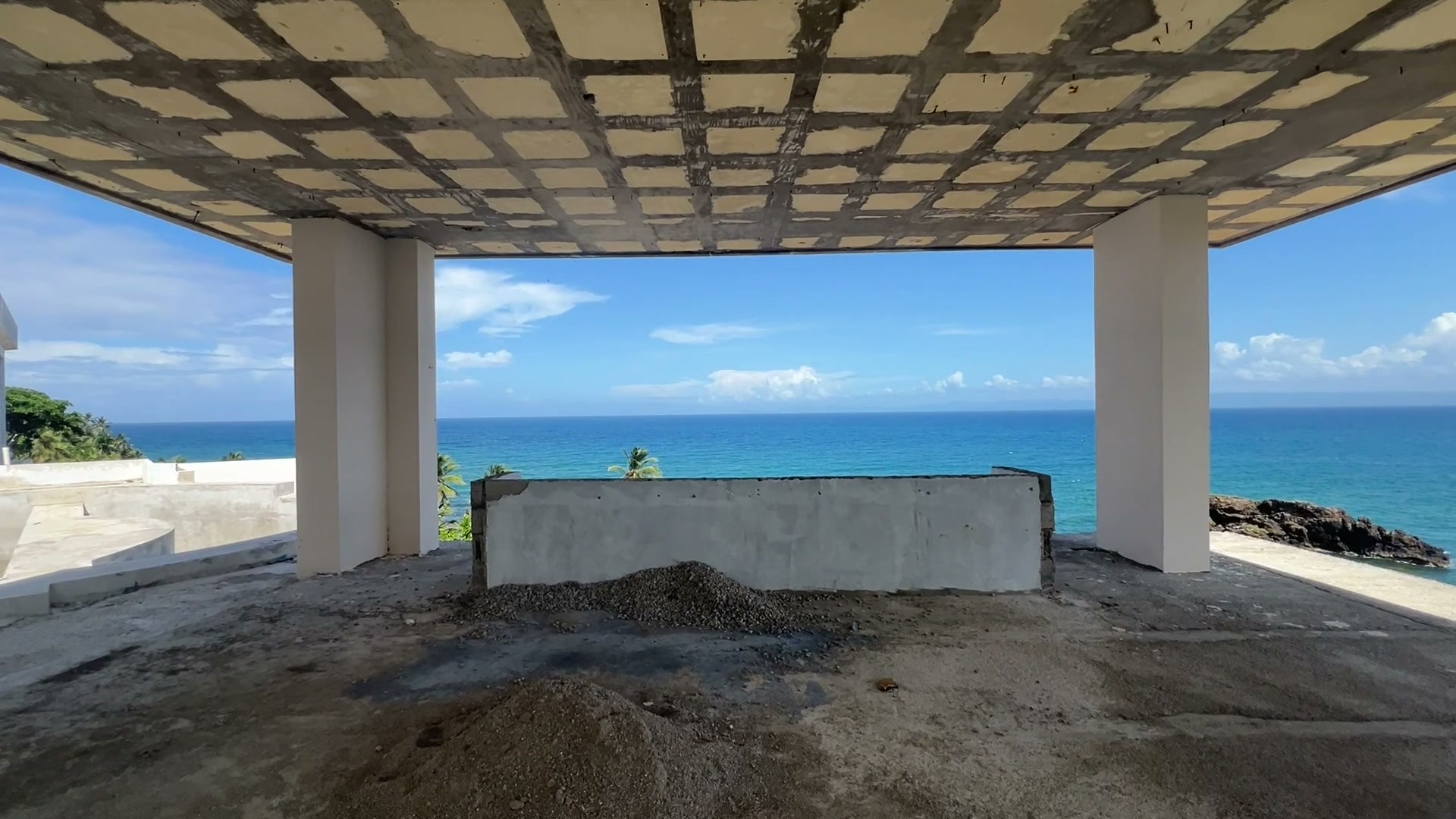 A covered terrace with a coffered ceiling, open to the bay