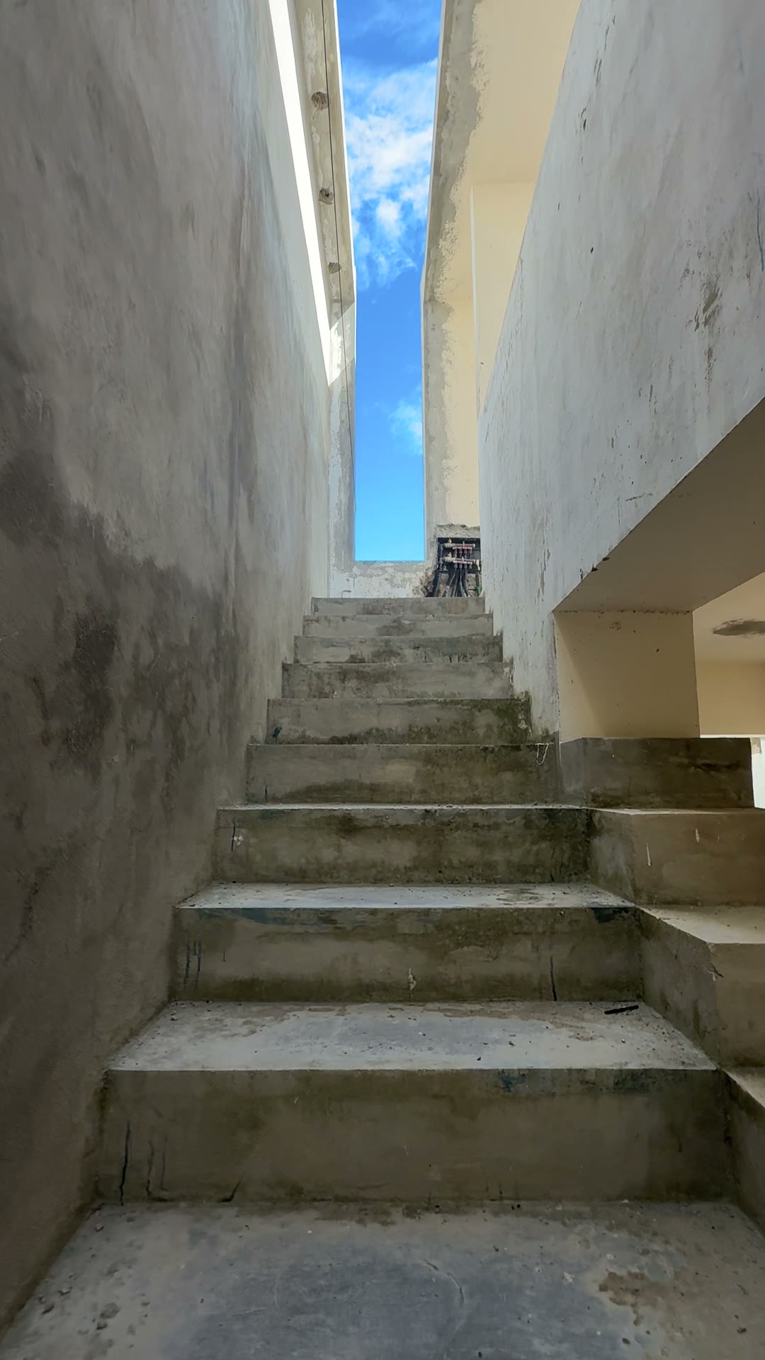 A stair rising between two walls toward the sky